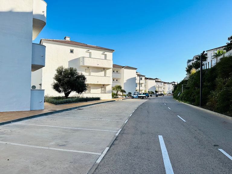 Quiet street with white buildings.